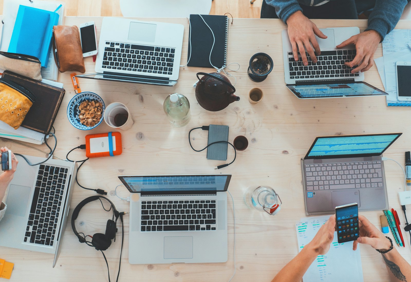 Bureau couvert d'ordinateurs, de carnets et de documents
